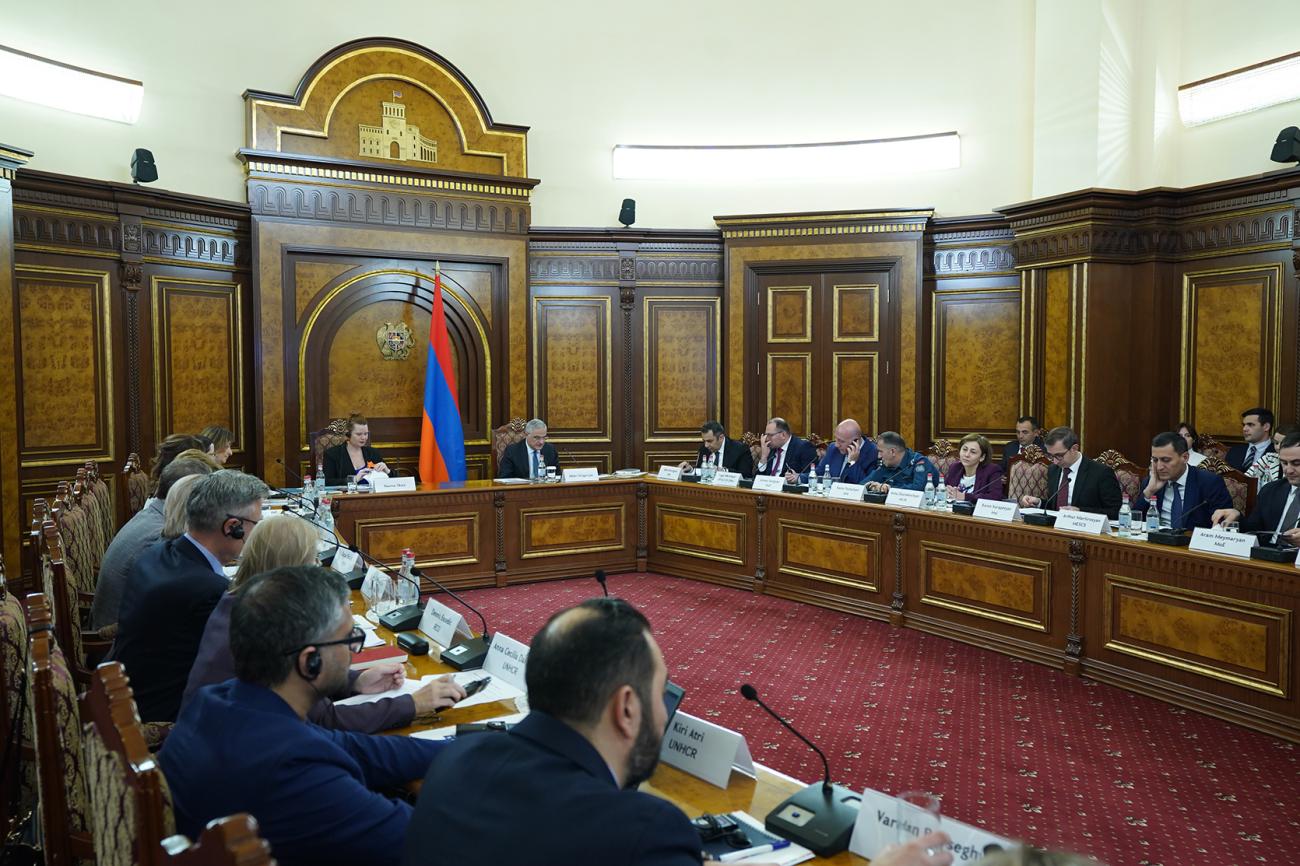 Officials seated at a government meeting room table with the Armenian flag