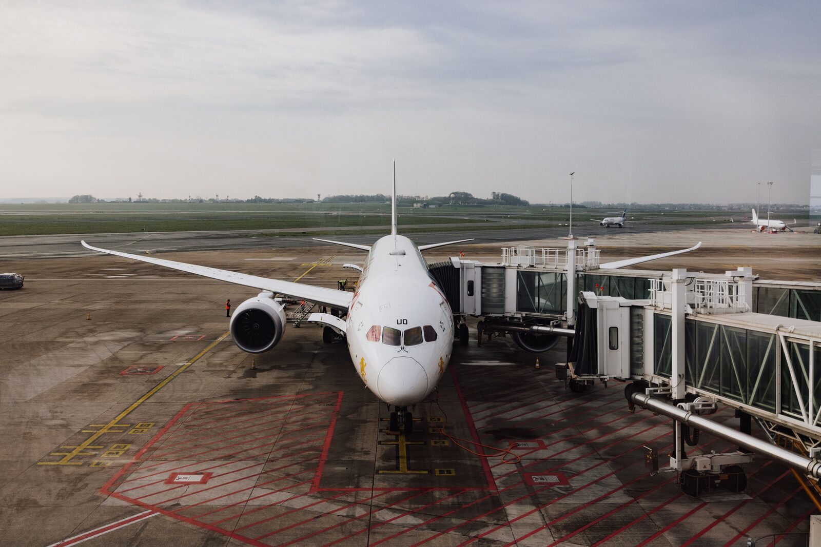A commercial aircraft docked at an airport jet bridge