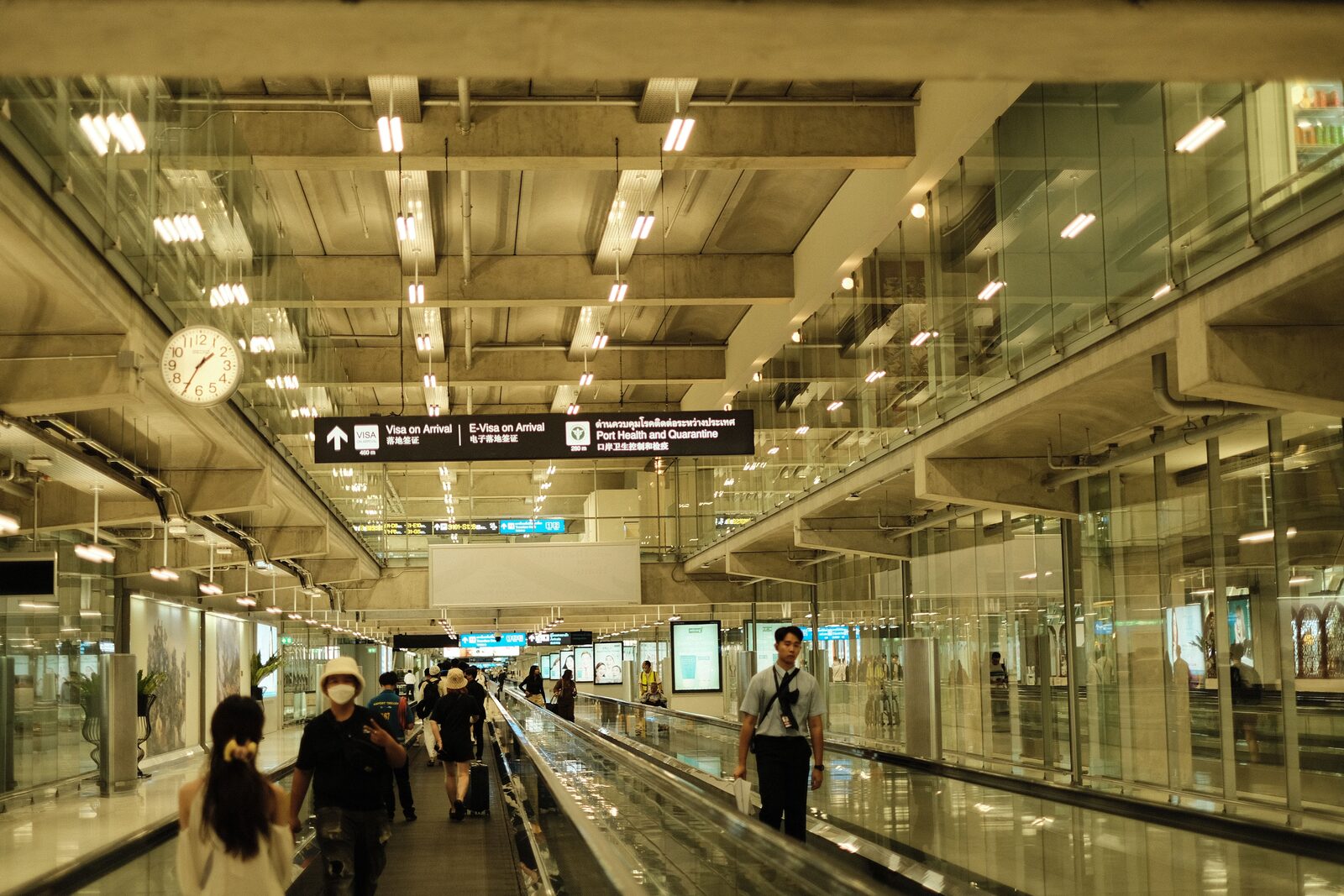 Airport terminal corridor with Visa on Arrival and immigration signage overhead
