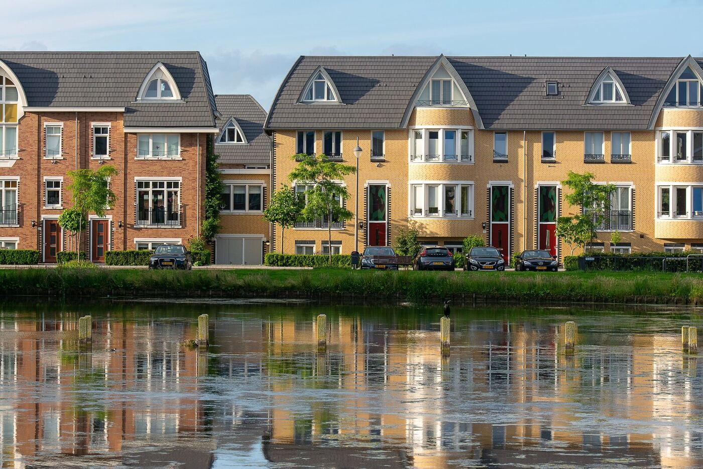 A row of European townhouses reflected in a canal